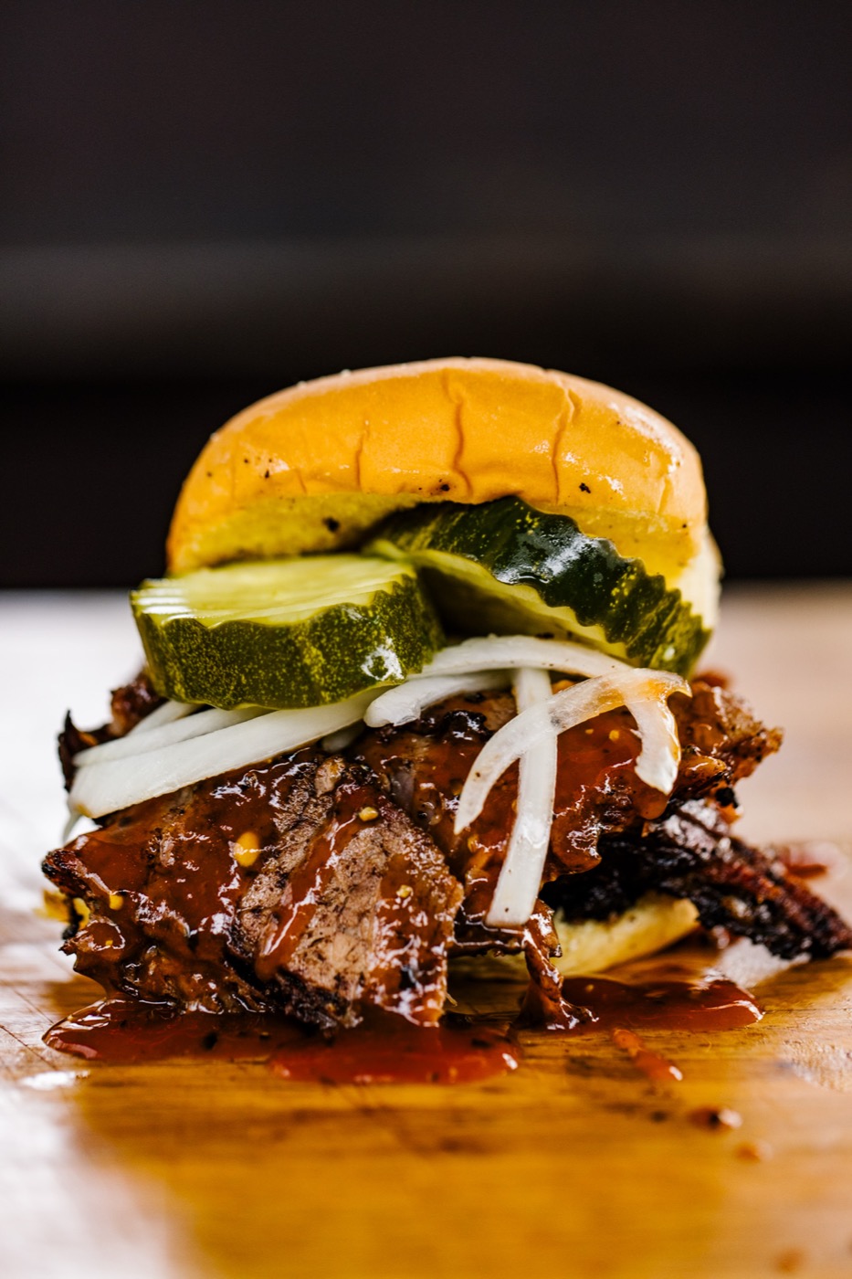 Brisket sandwich on brioche with pickles and onions